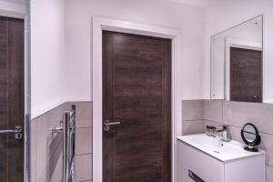 a bathroom with a wooden door and a sink at Modern Studio Apartment near Old Trafford in Manchester