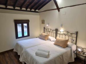 a bedroom with two beds with white sheets at Lanchas de La Vera in Madrigal de la Vera