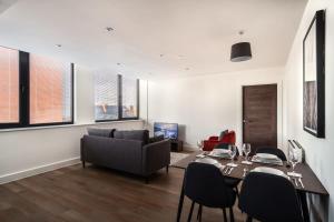 Modern & Spacious 2 Bed Apartment by Old Trafford في مانشستر: غرفة معيشة مع طاولة وأريكة