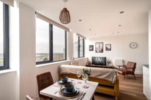 a dining room with a table and chairs and windows at Sleek 1 Bedroom Apartment by Old Trafford in Manchester