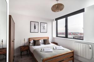 a bedroom with a bed and a large window at Sleek 1 Bedroom Apartment by Old Trafford in Manchester