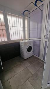 a washing machine in a laundry room with windows at Costa rooms apartament in Livorno