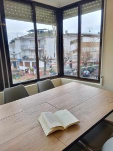 um livro sobre uma mesa de madeira com janelas em Los Cuatro Caños em Madrigal de la Vera