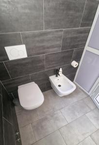 a bathroom with a white toilet and a sink at Costa rooms apartament in Livorno