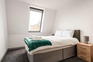 a bedroom with a large bed with a window at Modern 1 Bed Budget Apartment in Central Halifax in Halifax