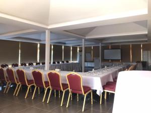 una sala de conferencias con una mesa larga y sillas en Olbios Marina Resort Hotel, en Kumkuyu