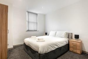 a bedroom with a large bed with two towels on it at Contemporary 1 Bed Budget Flat in Central Halifax in Halifax