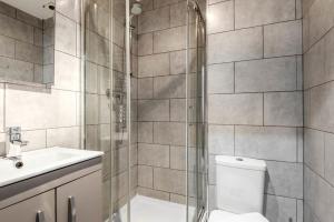 a bathroom with a shower and a toilet and a sink at Lovely 1 Bed Budget Apartment in Central Halifax in Halifax