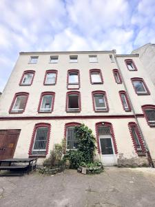 a large white building with red shuttered windows at NOOK Design Apartments with Kitchen in Berlin