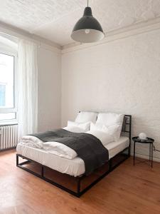 a bedroom with a bed with white walls and a lamp at NOOK Design Apartments with Kitchen in Berlin