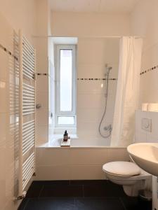 a bathroom with a shower and a toilet and a sink at NOOK Design Apartments with Kitchen in Berlin