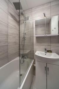 a bathroom with a sink and a tub and a shower at 3 Bedroom Old Street Apartment - Amazing Views in London