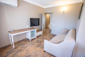 a living room with a couch and a tv at Olbios Marina Resort Hotel in Kumkuyu