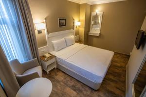 a small room with a bed and a chair at Olbios Marina Resort Hotel in Kumkuyu