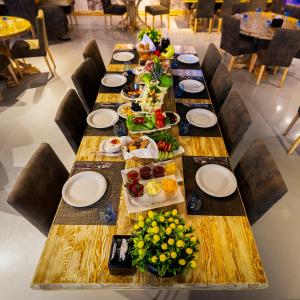 a long wooden table with plates and food on it at Olbios Marina Resort Hotel in Kumkuyu