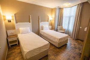 a room with two beds in a hotel room at Olbios Marina Resort Hotel in Kumkuyu