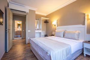 a bedroom with a large white bed in a room at Olbios Marina Resort Hotel in Kumkuyu