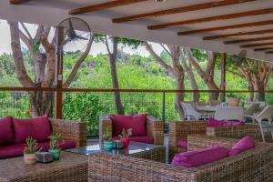 a patio with purple pillows and tables and trees at Olbios Marina Resort Hotel in Kumkuyu