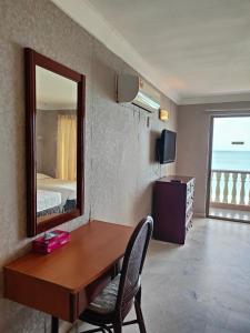 a room with a desk with a mirror and a bedroom at BAYU BEACH RESORT in Port Dickson