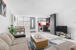 ein Wohnzimmer mit einem Sofa und einem Tisch in der Unterkunft Smart 1 Bedroom Apartment in Central Woking in Woking