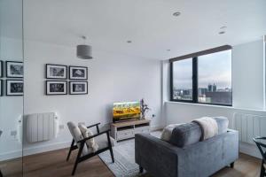 uma sala de estar com um sofá e uma televisão em Lovely Modern 1 Bed Apartment by Old Trafford em Manchester