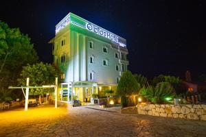 a building with a sign on it at night at Olbios Marina Resort Hotel in Kumkuyu