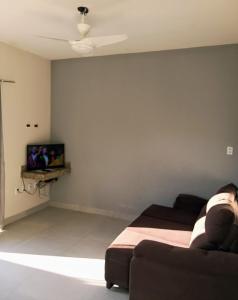 sala de estar con sofá y TV en Casa Luxo e Sossego 50m da Praia en Guriri