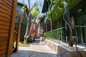 a walkway in front of a green building with trees at Olbios Marina Resort Hotel in Kumkuyu