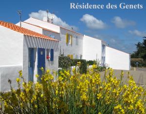 um edifício branco com flores amarelas à frente em Maison de vacances à l'Ile d'Yeu - Les Genêts em Ker Pierre Borny