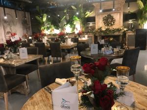 a restaurant with tables and chairs with flowers on them at Olbios Marina Resort Hotel in Kumkuyu