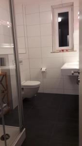 La salle de bains est pourvue de toilettes et d'un lavabo. dans l'établissement FeWo Wurmberg Domizil ZZ-BRAUNLAGE, à Braunlage