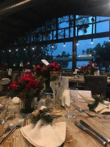 a table with red flowers and silverware on it at Olbios Marina Resort Hotel in Kumkuyu