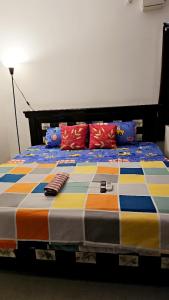 Una cama con mantas y almohadas coloridas. en Ruchika's Orchid en Hyderabad