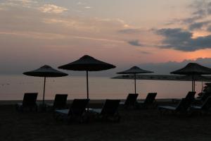 a group of chairs and umbrellas on a beach at Olbios Marina Resort Hotel in Kumkuyu