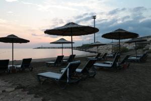 a group of chairs and umbrellas on a beach at Olbios Marina Resort Hotel in Kumkuyu