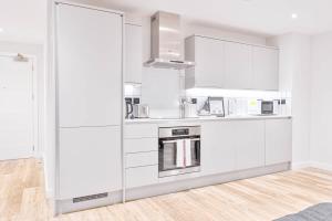 a white kitchen with white cabinets and appliances at Lovely Central Birmingham 2 Bed Apartment in Birmingham