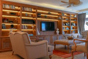 a living room with a large wooden wall with a tv at Olbios Marina Resort Hotel in Kumkuyu