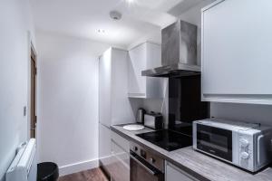 a small kitchen with a microwave and a counter at 1 Bed Apartment in Central Liverpool w Balcony in Liverpool