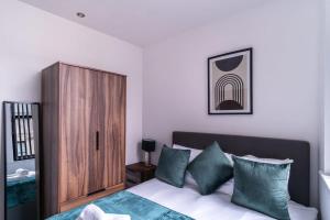 a bedroom with a bed and a wooden cabinet at 1 Bed Apartment in Central Liverpool w Balcony in Liverpool
