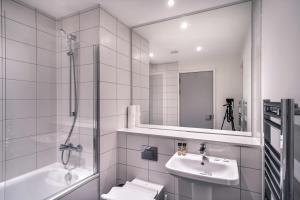 y baño blanco con lavabo y ducha. en Spacious 1 Bed Apartment in Central Manchester en Mánchester