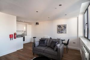 a living room with a couch and a table at Modern & Spacious 1 Bed Apartment - Old Trafford in Manchester