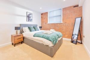 a bedroom with a bed and a brick wall at Stylish 2 Bed Apartment in Burton-on-Trent in Burton upon Trent