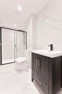 uma casa de banho branca com um lavatório e um WC em Stylish 2 Bed Apartment in Burton-on-Trent em Burton upon Trent