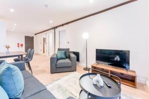 a living room with a couch and a tv and a table at Stylish 2 Bed Apartment in Burton-on-Trent in Burton upon Trent