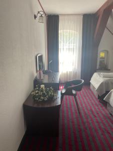 a hotel room with a desk and a bed at Bajkowy Zakątek in Gietrzwałd
