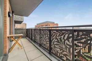 a balcony with a wooden chair on a balcony at Smart 1 Bedroom Apartment in Canning Town in London