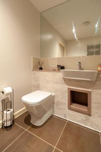 a bathroom with a white toilet and a sink at Smart 1 Bedroom Apartment in Canning Town in London