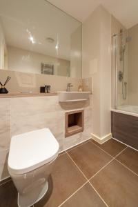 uma casa de banho com um WC, um lavatório e um chuveiro em Smart 1 Bedroom Apartment in Canning Town em Londres