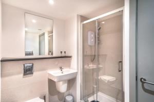 a white bathroom with a sink and a shower at Smart 1 Bedroom Apartment in Liverpool Centre in Liverpool