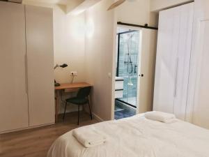 ein Schlafzimmer mit einem Bett und einem Schreibtisch mit einem Stuhl in der Unterkunft Confortable et cosy appartement en centre-ville in Aix-en-Provence
